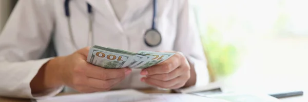 Doctor Counts Money Her Hands Medical Clinic Close Many Dollar — Zdjęcie stockowe