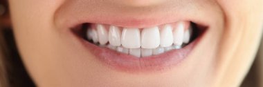 Close-up of female showing healthy smooth white teeth. Concept of hygiene and dental care.