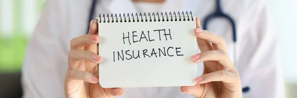 Female Doctor Shows Notepad Words Health Insurance Close Health Worker Stockbild