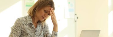 Tired young woman in the office looks into the diary, close-up. Workload, fatigue. Burnout at work