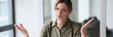 The young woman in the office divorced her hands in bewilderment, a close-up. Problem at work, gesture