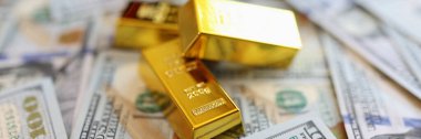 Close-up of stack small golden ingots on pots of money cash. Accumulation of wealth and self-insurance concept