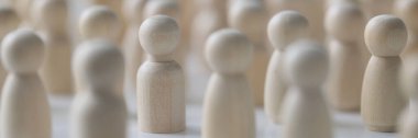 Crowd of people and society concept. Many wooden figures standing close to each other, shallow depth of field.