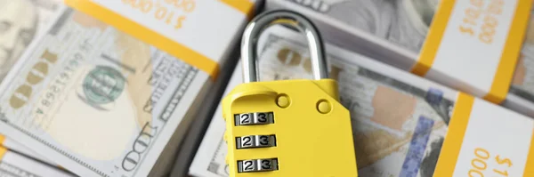 Padlock with combination on background of dollar banknotes. Financial security, money protection and safety concept.