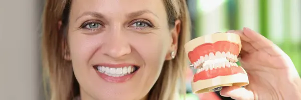 Χαμογελαστή Γυναίκα Οδοντίατρος Δείχνει Σαγόνια Τεχνητά Δόντια Κοντά Έννοια Της — Φωτογραφία Αρχείου