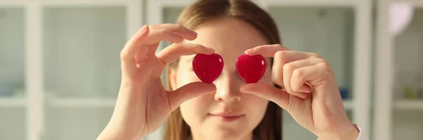 Νεαρή Γυναίκα Γιατρός Κρατά Κόκκινες Καρδιές Χέρια Ενάντια Στα Μάτια — Φωτογραφία Αρχείου