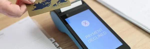 stock image Woman puts credit card to terminal trying to pay for services online. Payment declined due to technical error. Device on wooden table in office closeup