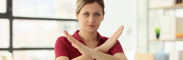 Woman manager shows Stop gesture at desk in company office closeup. Blonde specialist denies customer request. Service refusal performance