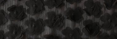 Giysi üretimi için tasarlanmış gri kumaşa eklenmiş siyah çiçekler. Yaratıcı desen ve tekstil malzemesi dokusu. Katalog fotoğraf örneği