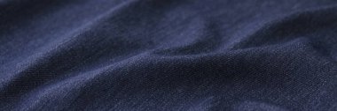 Çarşaf dükkanında giysi dikmek için kullanılan buruşuk koyu mavi kumaş. Arka plan olarak tekstil malzemesi dokusu. Örneklerin katalog fotoğrafı