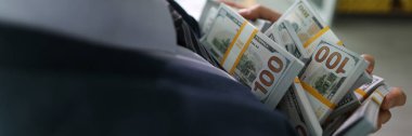 Başarılı menajer, sayılan para yığınlarını elinde tutuyor. Takım elbiseli adam müşteriyle başarılı bir emlak anlaşmasından büyük kar elde ediyor.