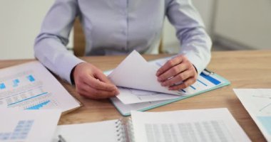 İş kadını proje istatistiklerini ve raporlarını analiz ediyor. Ofiste grafik belgelerle çalışmak