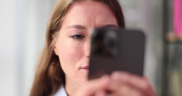 一个多愁善感的女人 拿着智能手机 看电子邮件或上网 认真的女人用手机 感觉很沮丧 — 图库视频影像