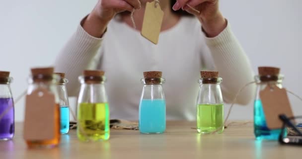 Çok Renkli Sıvıyla Şeffaf Kozmetik Şişesi Kozmetik Uzmanı Etiketi Yapıştırıyor — Stok video
