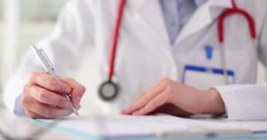 Kadın doktor terapistin elleri tıbbi belgelere not alıyor. Sağlık sigortası ya da hastanın tıbbi geçmişi