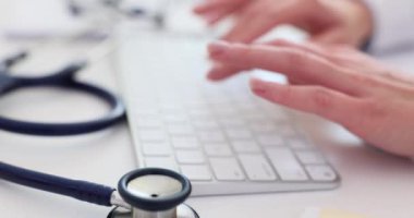 Bilgisayar klavyesi ve teletıp kullanan kadın doktorların yakın çekimi. Çevrimiçi tıp ve uzak tıbbi bakım
