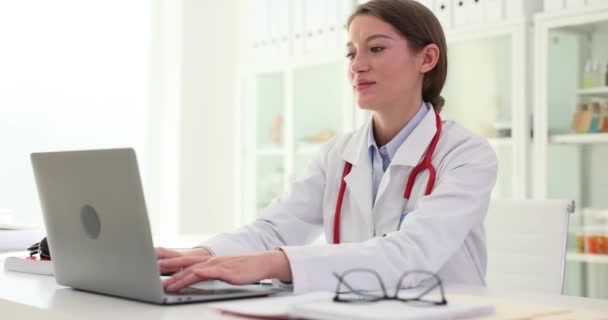 女性医師はラップトップで働き 医療機関で閉鎖する 医療従事者の労働日の終わり — ストック動画