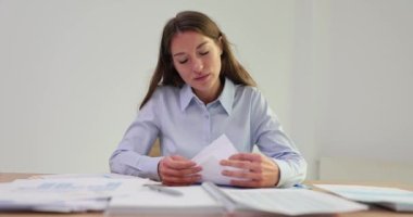 İş kadını sözleşmeleri, yasal anlaşmaları ve belgeleri inceliyor. İş kadını ofiste oturuyor ve bir sürü belge okuyor.