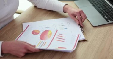 İş kadını ve yeni pazarlama planı ve satış istatistiklerini belgelerle analiz ediyor. Proje raporunda mali sonuçlarla çalışır ve anlaşmanın faydalarını sunar