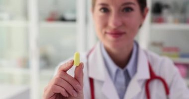 Bayan KBB doktoru klinikte kulak tıkacı takıyor. Suyun ve yabancı cisimlerin gürültüsünden korunmak için kullanılır.