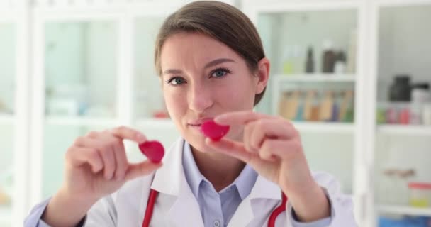 Cardiologista Detém Dois Corações Vermelhos Brinquedo Frente Dos Olhos Closeup — Vídeo de Stock