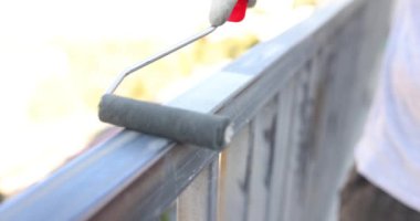 Ressam metal parçaları silindirle griye boyar. Metal boruların pas ve aşınmadan korunması ve inşasında boyama çalışmaları