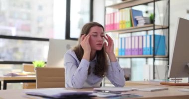 Yorgun, stresli iş kadını iş yerinde baş ağrısı ve masaj yapıyor. Müdür ofiste fazla çalışmaktan yoruldu.
