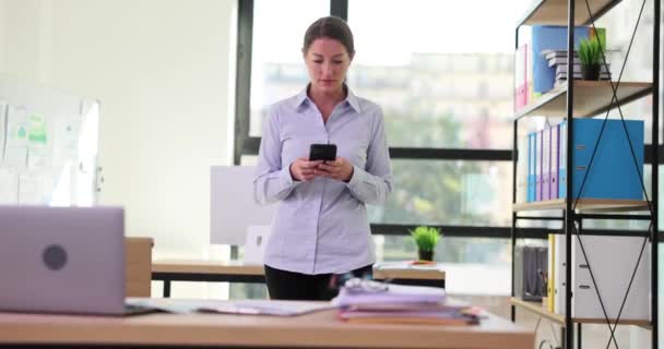 Γυναίκα Διευθυντής Εισέρχεται Στο Γραφείο Κοιτάζει Smartphone Και Συγκρούεται Τραπέζι — Αρχείο Βίντεο