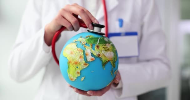 Доктор Стетоскопом Слушает Глобус Концепция Всемирного Дня Здоровья — стоковое видео