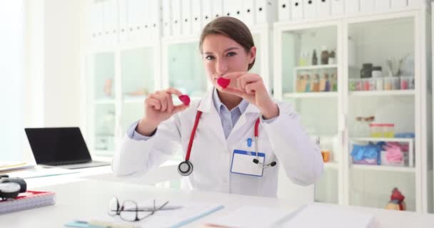 医師の看護師は手と目で赤いハートを保持しています 心臓の健康を大切にする — ストック動画