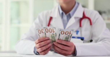 Doktor kardiyolog yakın plan para sayıyor. Tıbbi hizmetlerin maliyeti