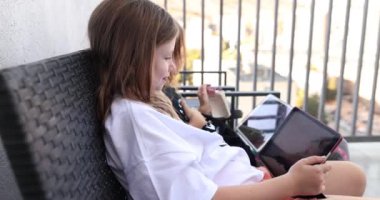 Modern çocuklar ve terasta tableti olan teknoloji. Arkadaşlar, arkadaşlık konsepti ve tabletli mutlu küçük kızlar.