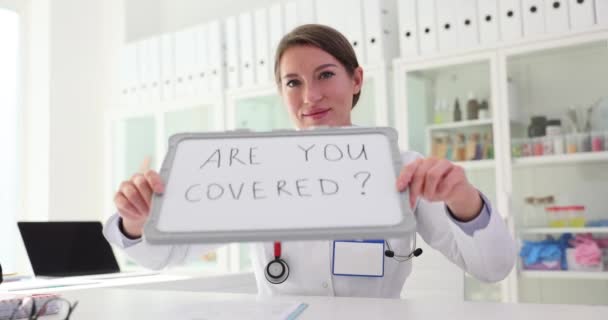 テキスト付きのタブレットを保持している医師の女性看護師は 生命保険と医療サービスをカバーされています — ストック動画
