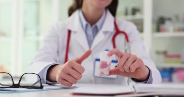クリニックで処方薬を所持している女性医師が親指を示しています 優れた結果と承認のサインを作るセラピスト — ストック動画