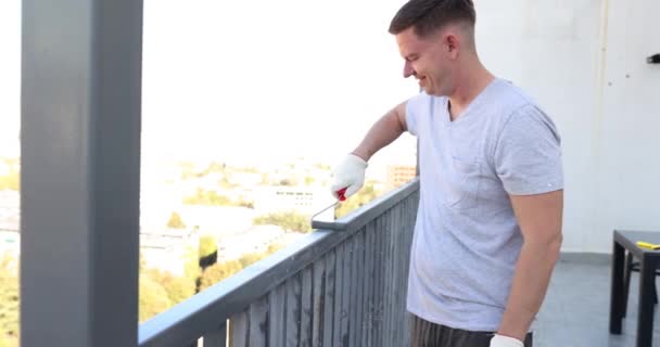 男人在户外用灰色清漆的特写画金属栏杆 粉刷滚筒 — 图库视频影像