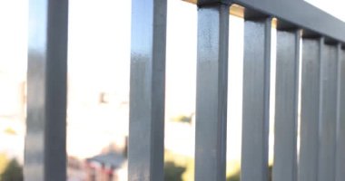 Binada metal parmaklıklar olan bir balkon. Gri metal çitler