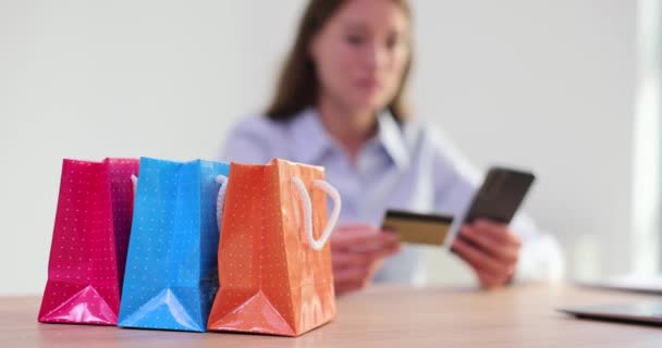 パッケージを持っている女性とスマートフォンと銀行カードを保持します オンラインショッピングと銀行サービスと販売 — ストック動画