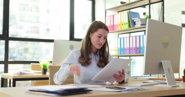 女性はオフィスの職場でビジネス文書を介してフリップします 安定した経済成長利益 — ストック動画
