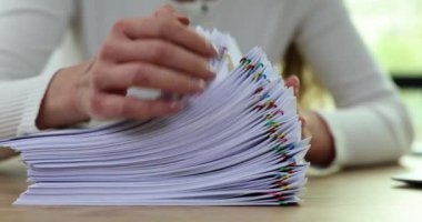 Raporlar için ofis masasında yığınla dosya var. Belge arayan ataçlı ve yöneticili çarşaf yığınları