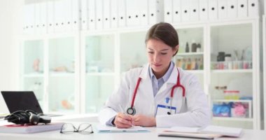 Kardiyolog klinikte reçete yazıyor. Tıbbi belge ve sigortanın hazırlanması