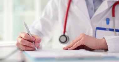 Kadın doktor reçete ve sigorta formu yazıyor. Tıbbi belgelerin kaydı.