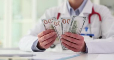 Tıp doktoru klinikte dolar sayıyor. Sağlık hizmetlerinin maliyeti ve yolsuzluk
