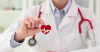 Doktor kardiyolog elinde modern tıp kardiyolojisinin kırmızı bir kalp ve simgesi tutuyor. Sağlık hizmetleri