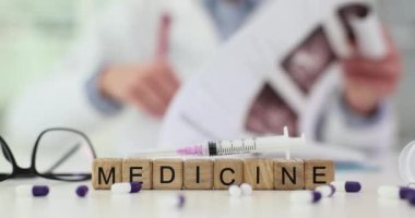 Kelime şırıngası ve klinikte hastalıkları tedavi eden tıbbi ilaçlar. Arka planda x-ray görüntüsünü inceleyen terapist