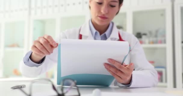 職場でテーブルに座っている文書を持つ医学研究と医師 プロの医療セラピストリーディング結果 — ストック動画