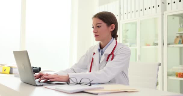Háziorvos Kórházban Laptoppal Nyomtatja Receptet Női Orvos Végez Online Kutatást — Stock videók