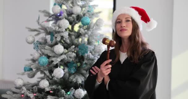Прекрасная Женщина Судья Шляпе Санта Клауса Держит Молоток Рождественскую Елку — стоковое видео