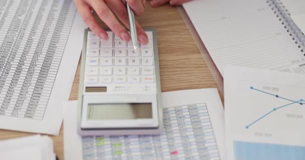 電卓を使用して机に座って 財務報告書と手のクローズアップ 会社の財務を計算する女性 — ストック動画