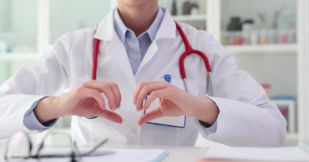 医師の心臓科医は 臨床閉鎖における心臓のジェスチャーを示しています 心血管疾患の診断と治療 — ストック動画