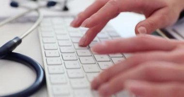 Doktor bilgisayarın klavyesini kapatıyor. Teletıp ve uzaktan tıbbi bakım